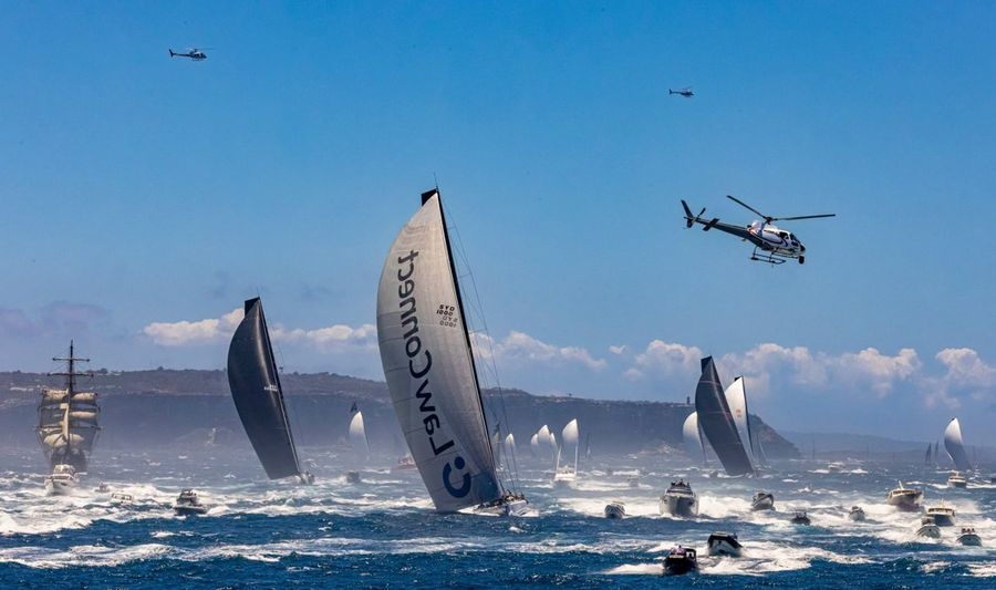 Spectator boats create plenty of wash as the fleet departs Sydney Harbour.