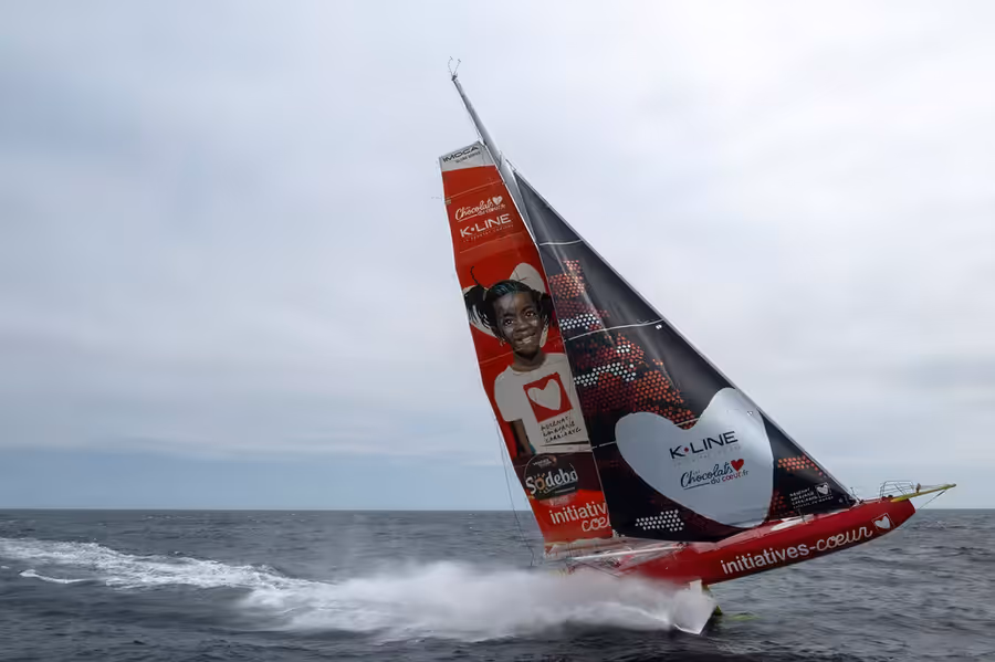 The IMOCA Initiatives Coeur flying at speed during a training session at sea.