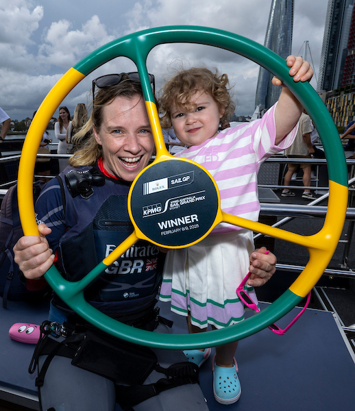Hannah Mills, strategist of Emirates Great Britain SailGP Team, with her daughter Sienna, on the Adrenaline Yacht holding the winers trophy after Emirates Great Britain SailGP Team won the final race on Race Day 2 of the KPMG Australia Sail Grand Prix in Sydney, Australia. Sunday 9 February 2025. Rolex SailGP Championship Event 3 Season 2025. Photo: Brett Phibbs for SailGP.