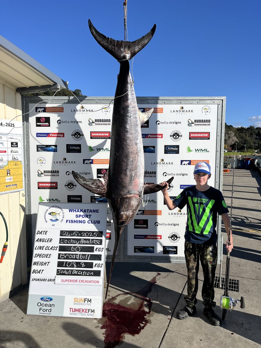 Lockey-Hawtree-stands-beside-Whakatane-Sport-Fishing-Clubs-weigh-board-Photo-credit-Waihau-Bay-Sport-Fishing-Club.jpg