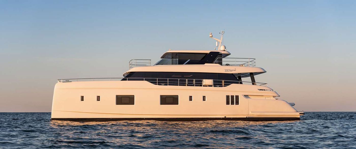 One of Sunreef's flagship catamarans glides across calm waters at sunset, showcasing its sleek, multi-level design.