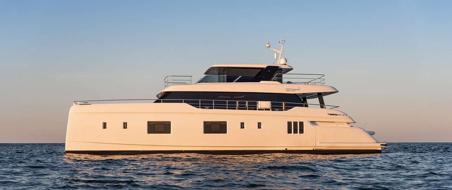 One of Sunreef's flagship catamarans glides across calm waters at sunset, showcasing its sleek, multi-level design.