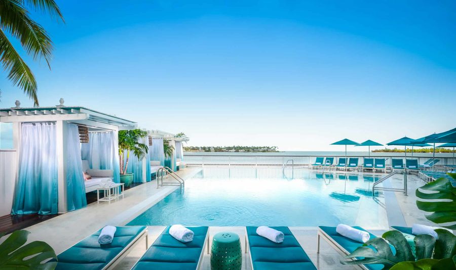 Guests relax by the pool and cabanas overlooking the water at Ocean Key Resort and Spa in Key West