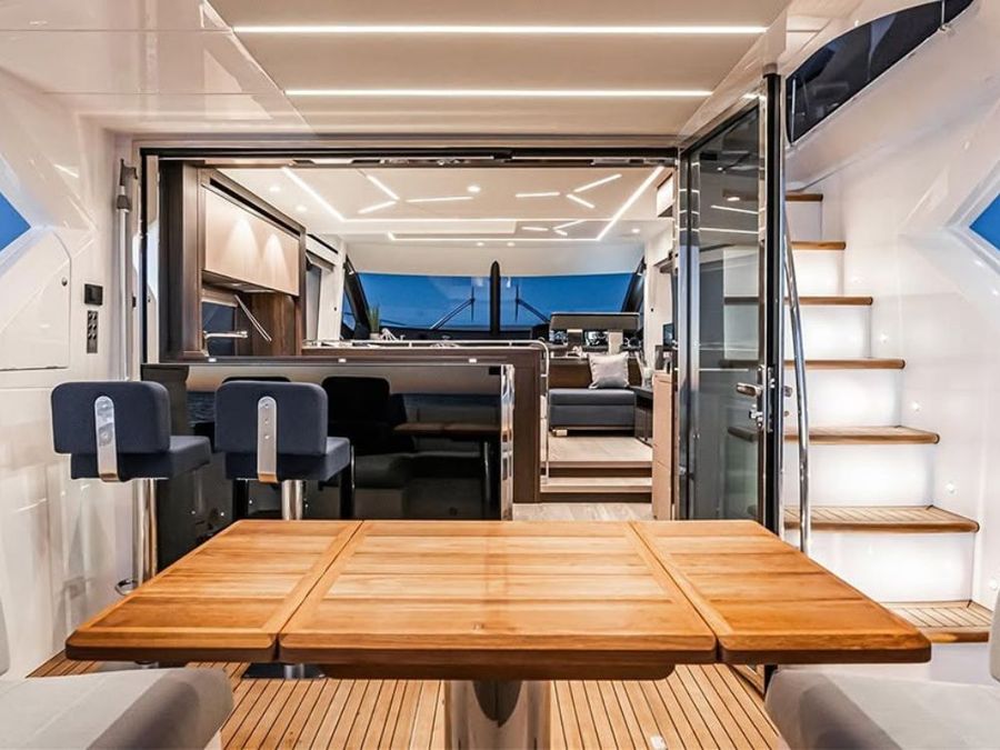 Sunseeker Manhattan 55 back deck area looking forwards into the saloon, galley and deck-level helm