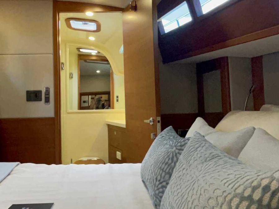 The guest cabin boasts a centrally positioned queen-size bed, providing easy access from both sides—a rare luxury in many boats