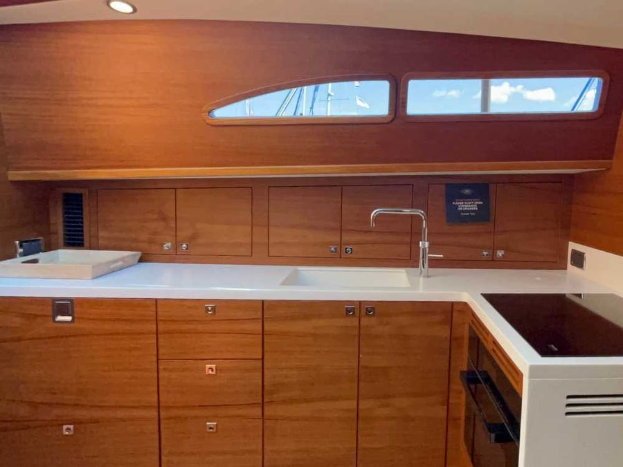 The indoor galley is well-appointed, featuring a full-sized sink, electric induction cooktop, and oven