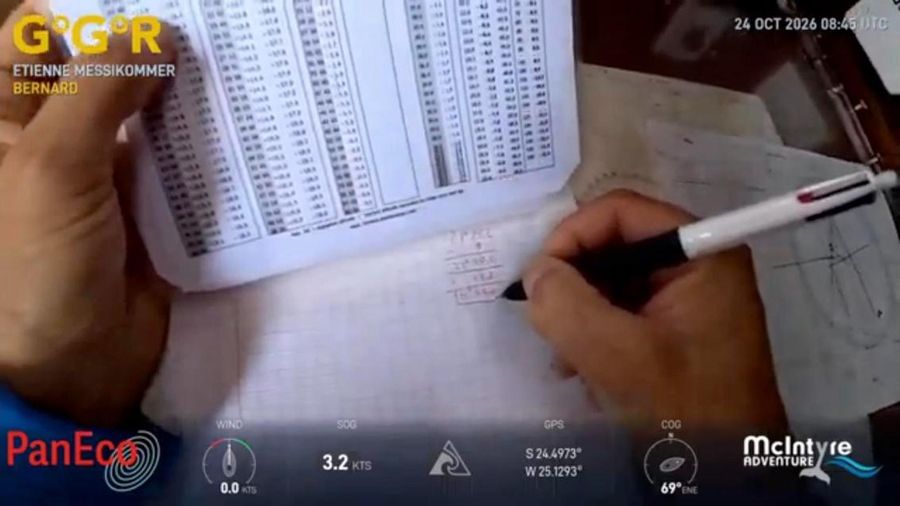 Close view of Etienne Messikommer's hands holding a printed table of sight reduction figures and writing calculations on squared paper with a pen