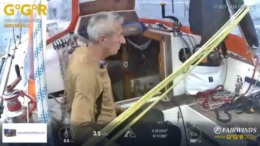 Ertan Beskardes in a tan shirt sitting in the cockpit of Miss Beagle with yellow lines across the foreground, the instrument overlay showing 3.5 knots.
