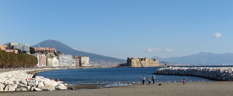 Mappatella Beach lines the Via Francesco Caracciolo promenade, with Castel dell'Ovo on the Megaride islet and Mount Vesuvius beyond.
