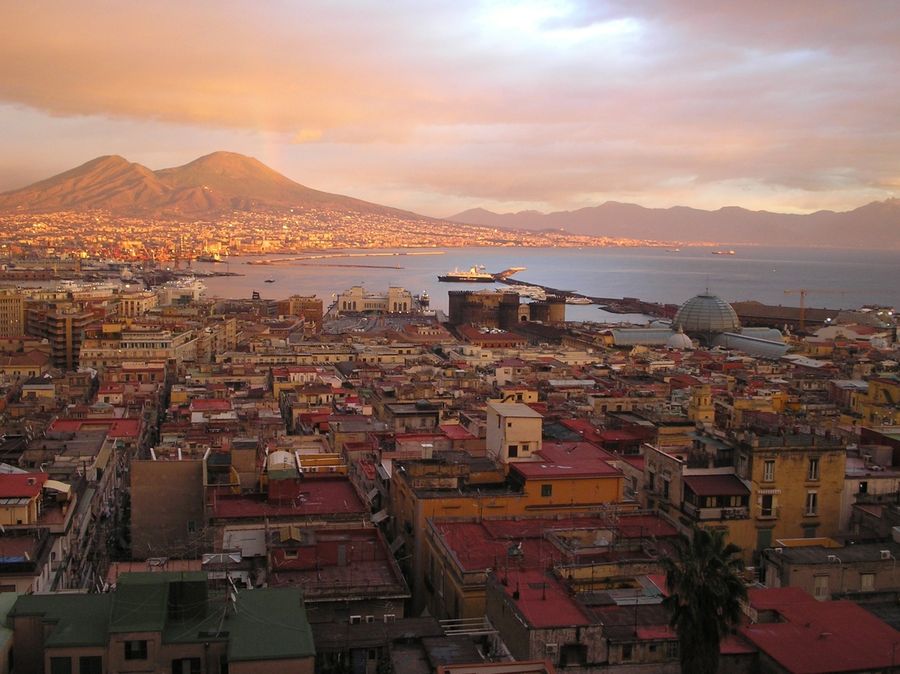 A sunset panorama captures Naples with Mount Vesuvius rising in the background, a fitting backdrop for the Cup's next chapter.